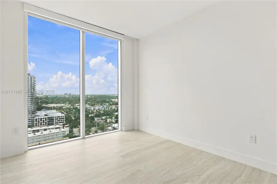 Floor-to-ceiling windows, neutral interior walls, and stone-finish flooring Floor-to-ceiling windows, neutral interior walls, and stone-finish flooring