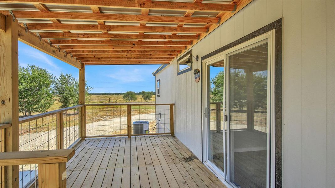 A spacious covered wood deck looks out over open pastures and country vistas.
