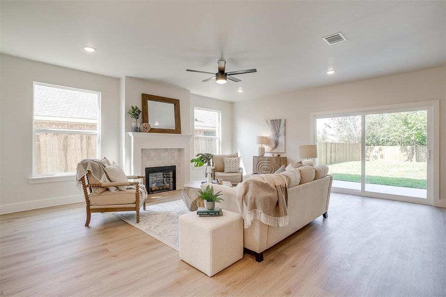 The living spacious living room has 9 foot ceilings, luxury vinyl flooring, and is anchored by a fireplace at the heart of the room