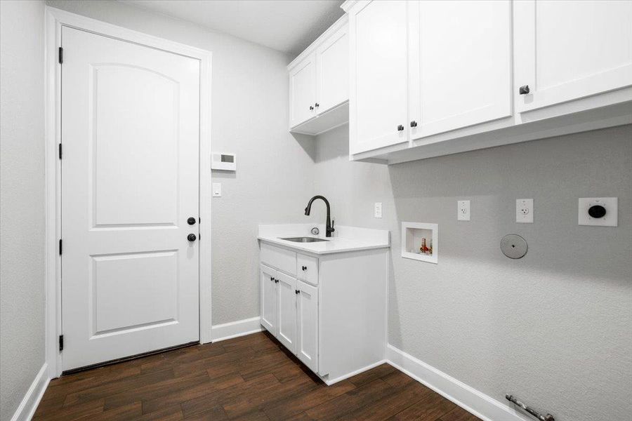 Laundry room featuring cabinet space, hookup for a washing machine, gas dryer hookup, electric dryer hookup, and dark wood-style flooring Laundry room featuring cabinet space, hookup for a washing machine, gas dryer hookup, electric dryer hookup, and dark wood-style flooring
