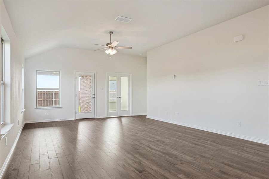 Unfurnished room with lofted ceiling, ceiling fan, and dark wood-type flooring