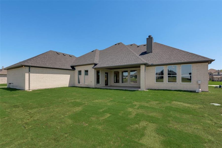 Rear view of house with a patio and a yard