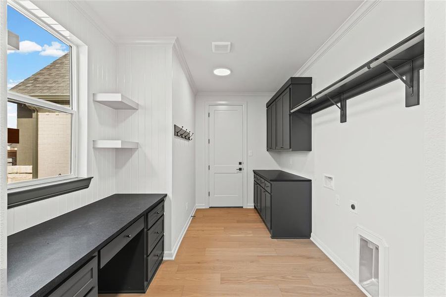 Laundry area featuring cabinet space, crown molding, light wood-style floors, an office area, and electric dryer hookup