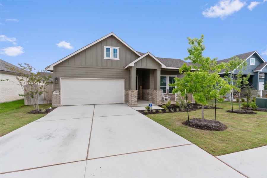 A welcoming facade with a covered porch and an integrated garage provides inviting curb appeal.