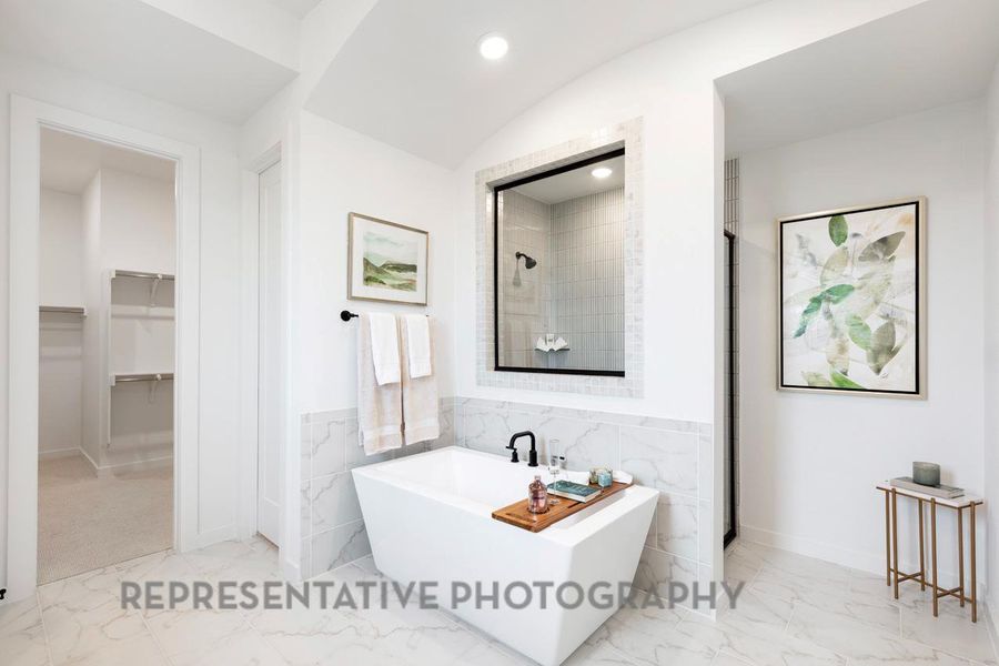 Full bath with recessed lighting, a spacious closet, marble finish floor, a freestanding bath, and tiled shower