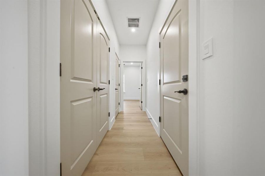 Hallway leading to a bedroom, Laundry room on the left and garage to the right.
