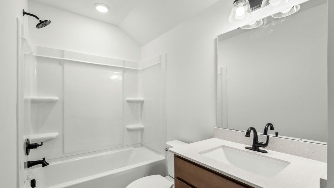 Upper-level bath with tub and storage at Chestnut Farms by DRB Homes
