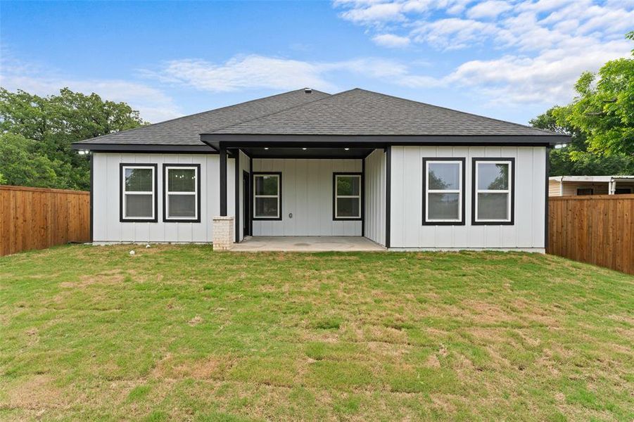 Back of house with a shingled roof, a patio, and board and batten siding Back of house with a shingled roof, a patio, and board and batten siding
