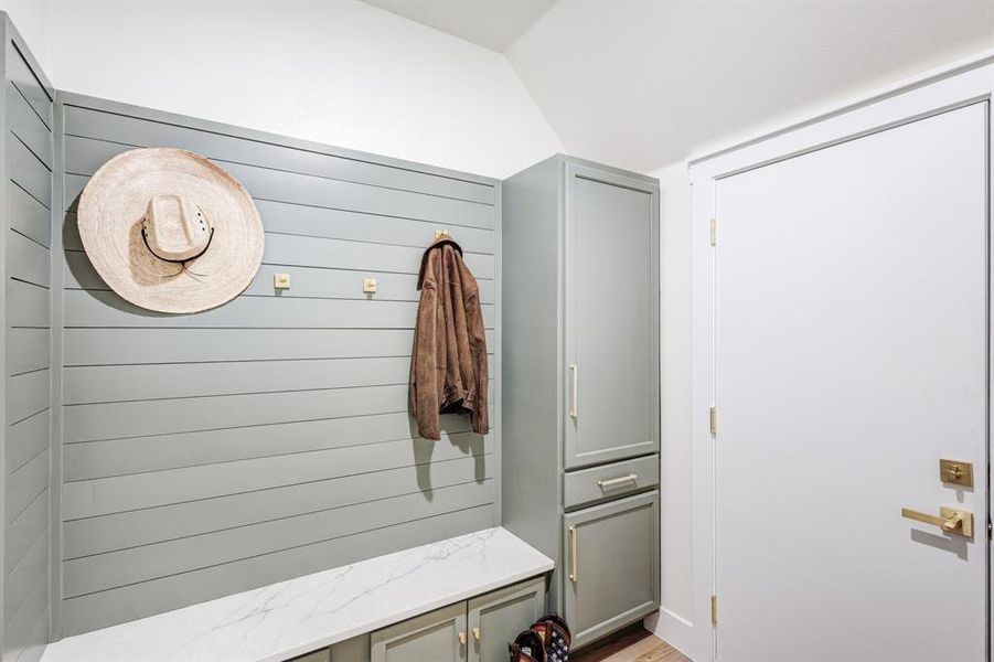 Mudroom with light hardwood / wood-style flooring and lofted ceiling