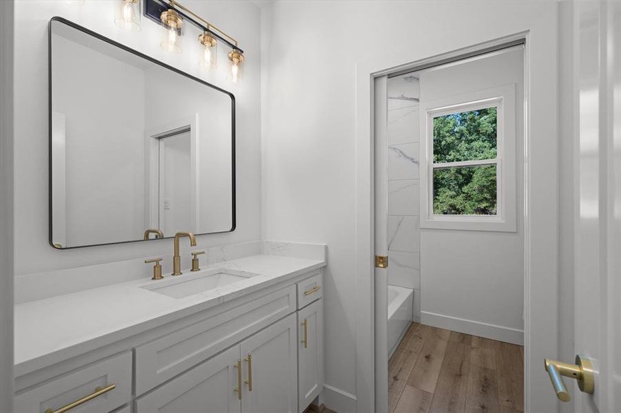 Full bath featuring vanity, light wood finished floors, and  shower combination