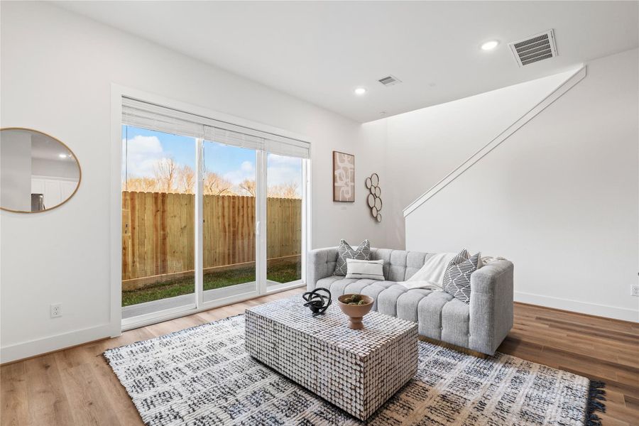 Featuring high ceilings, recessed lighting, and crisp white walls, this living area offers a bright and airy atmosphere.