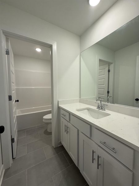 Bathroom featuring vanity and dark tile patterned floors