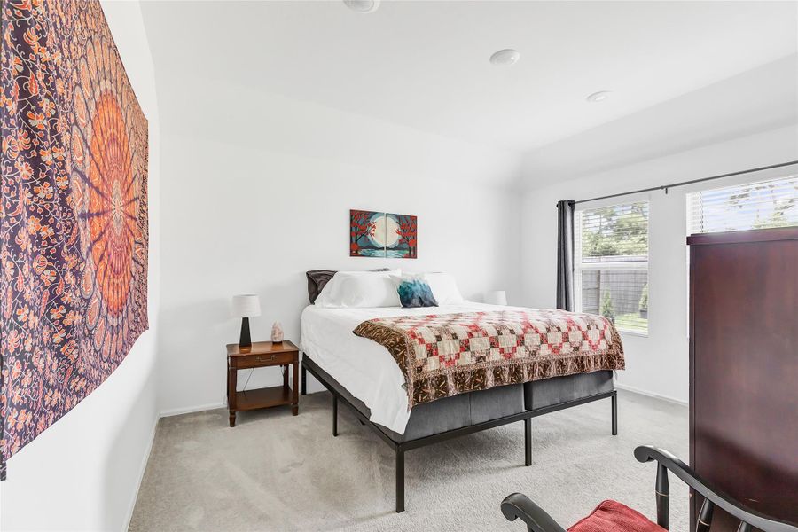 Primary bedroom has a back yard view. Bedrooms have carpet.