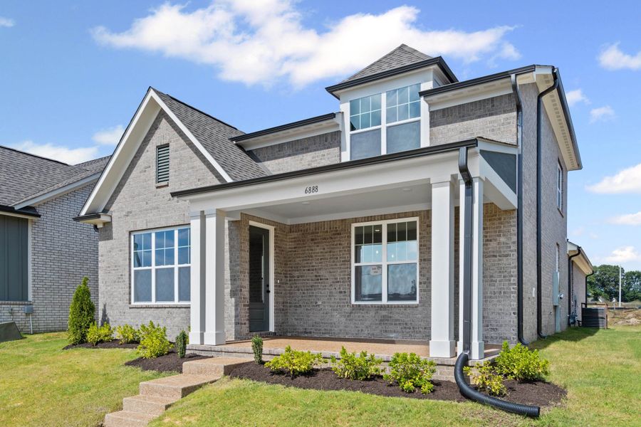 View of front facade with covered porch, brick siding, and a front yard View of front facade with covered porch, brick siding, and a front yard