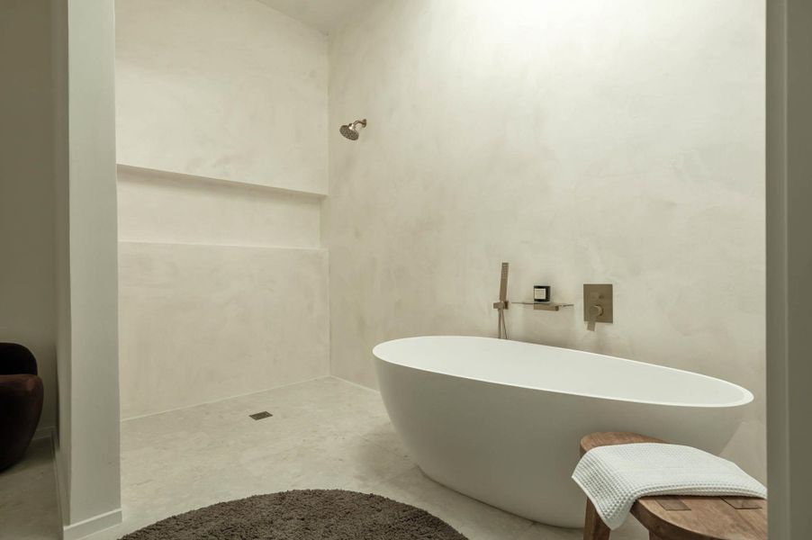 Full bathroom featuring a sitting area and a laundry room.
