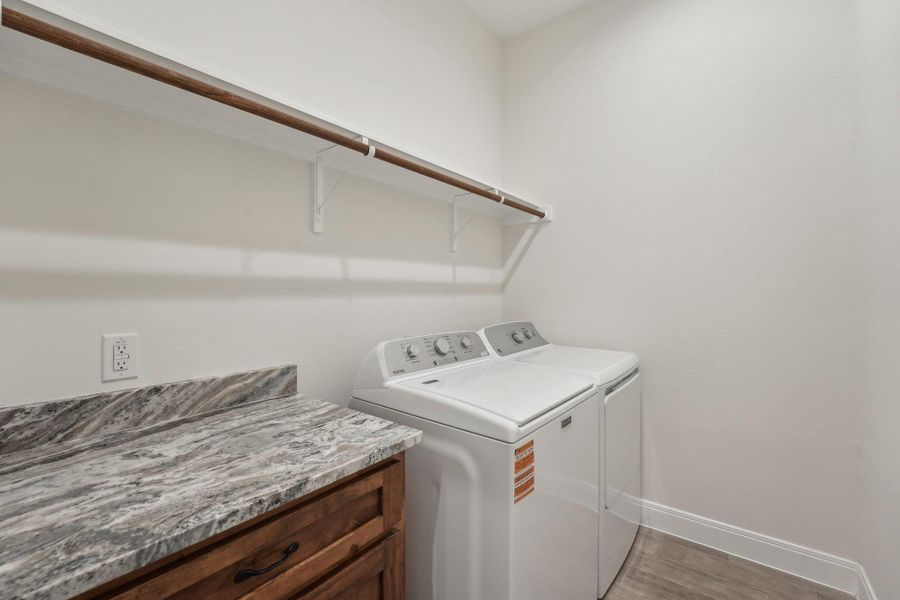 Clothes washing area with washer and dryer, baseboards, wood plank tile floor, and laundry area Clothes washing area with washer and dryer, baseboards, wood plank tile floor, and laundry area