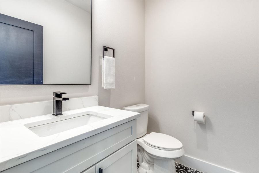 Half bathroom featuring vanity and toilet