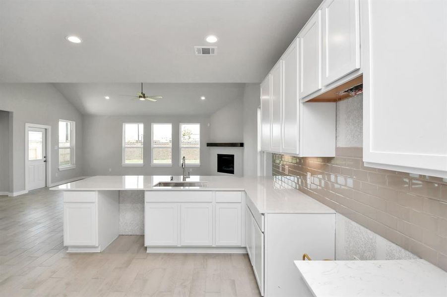 Culinary haven, featuring granite countertops, a tile backsplash, stainless steel appliances (to be installed), and 42” upper cabinets.