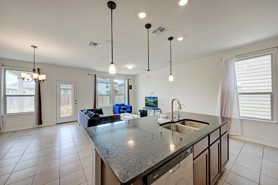 Granite counters and stainless steel appliances complete this open-concept kitchen and living area.
