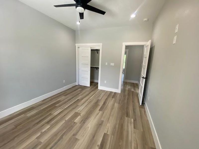 A cozy bedroom with a modern ceiling fan and durable vinyl plank flooring throughout. A cozy bedroom with a modern ceiling fan and durable vinyl plank flooring throughout.