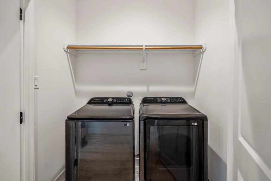 Upper-level utility room with side-by-side washer and dryer—conveniently located next to the primary and guest bedroom.