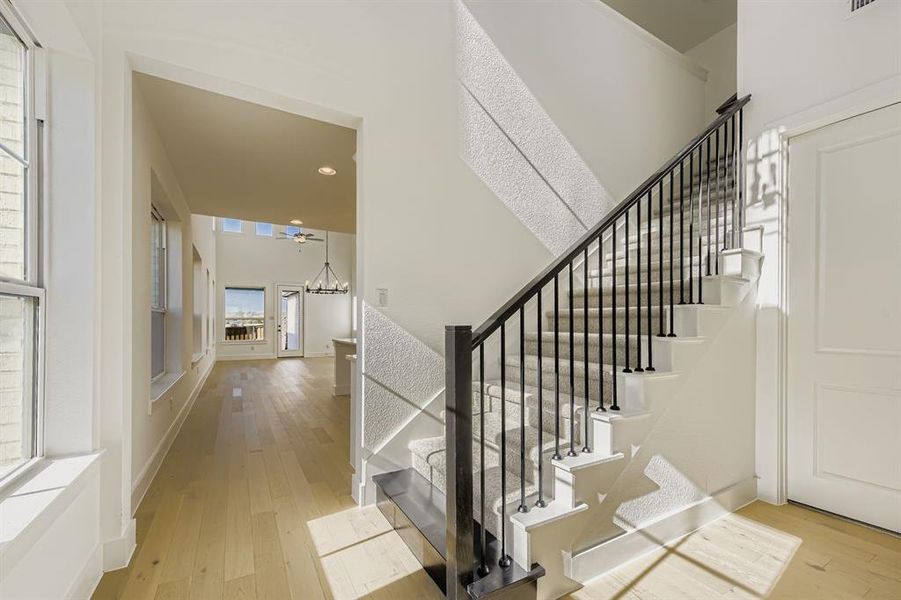Stairs featuring wood-type flooring, a chandelier, and recessed lighting