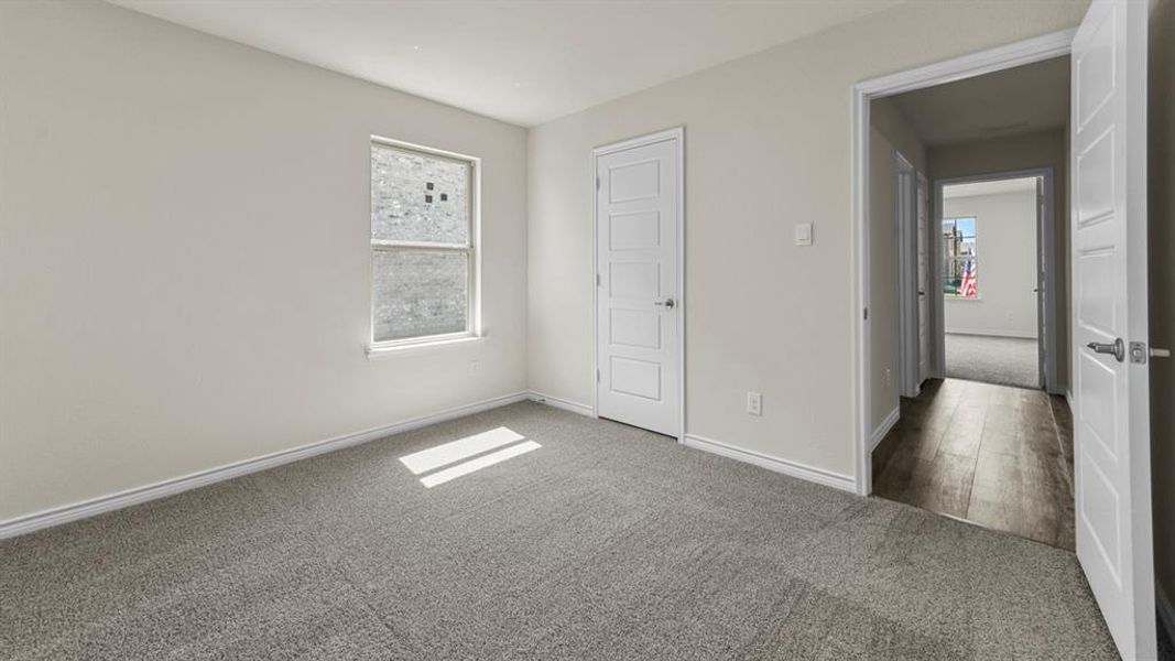 The property features a room with light grey carpet, white walls, and a window providing natural light