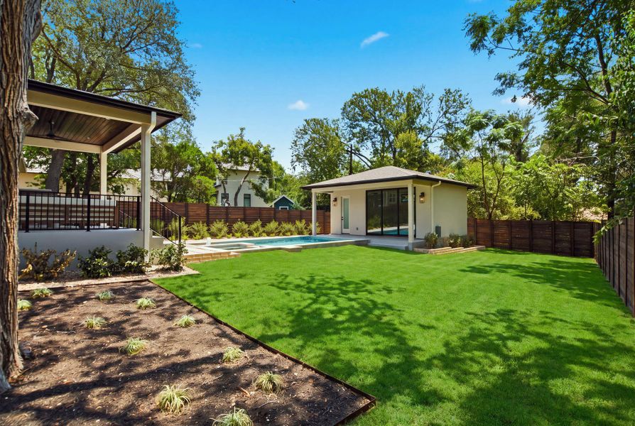 Manicured lawns and a sparkling pool define this private backyard oasis.