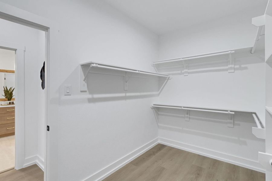Generous walk-in closet with built-in shelving and ample hanging space. Generous walk-in closet with built-in shelving and ample hanging space.