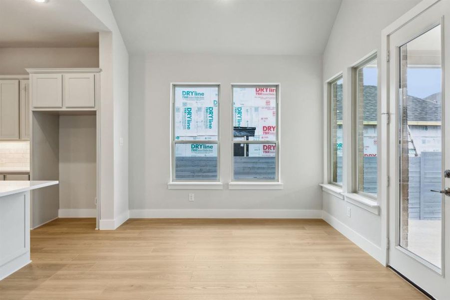 Unfurnished dining area with light wood-style flooring and baseboards
