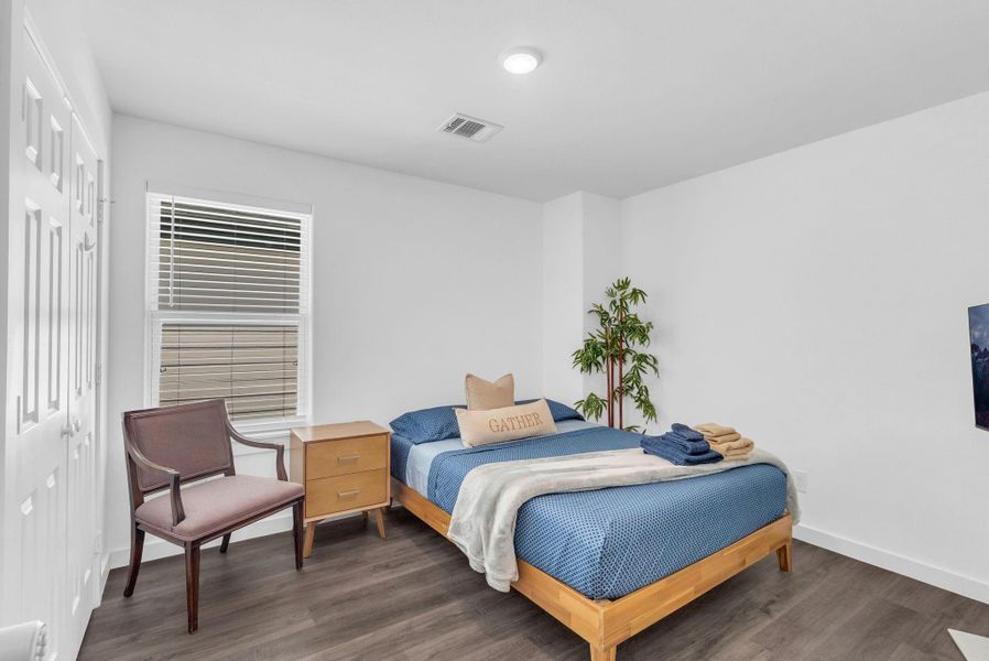 This bedroom features a cozy setup with a wooden bed, blue bedding, and a nightstand. The space is accented and currently utilized as Airbnb. This bedroom features a cozy setup with a wooden bed, blue bedding, and a nightstand. The space is accented and currently utilized as Airbnb.