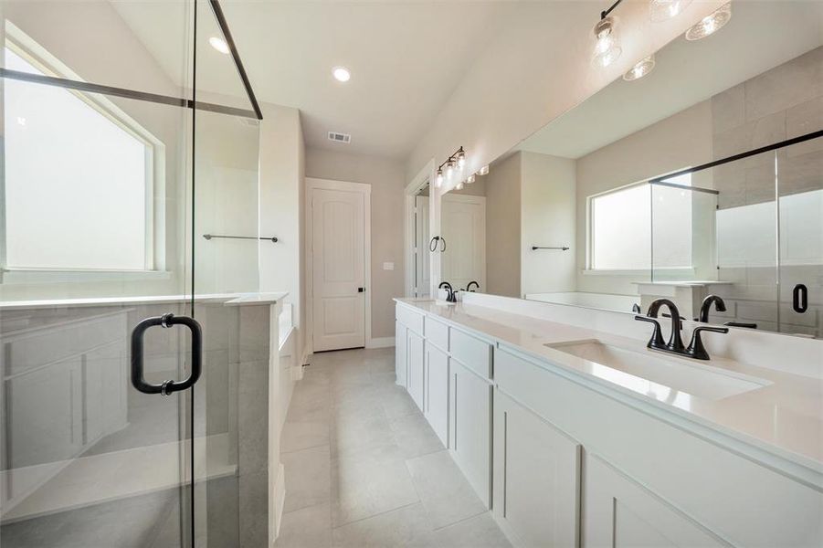 Bathroom with double vanity, a stall shower, a bath, tile patterned floors, and recessed lighting Bathroom with double vanity, a stall shower, a bath, tile patterned floors, and recessed lighting