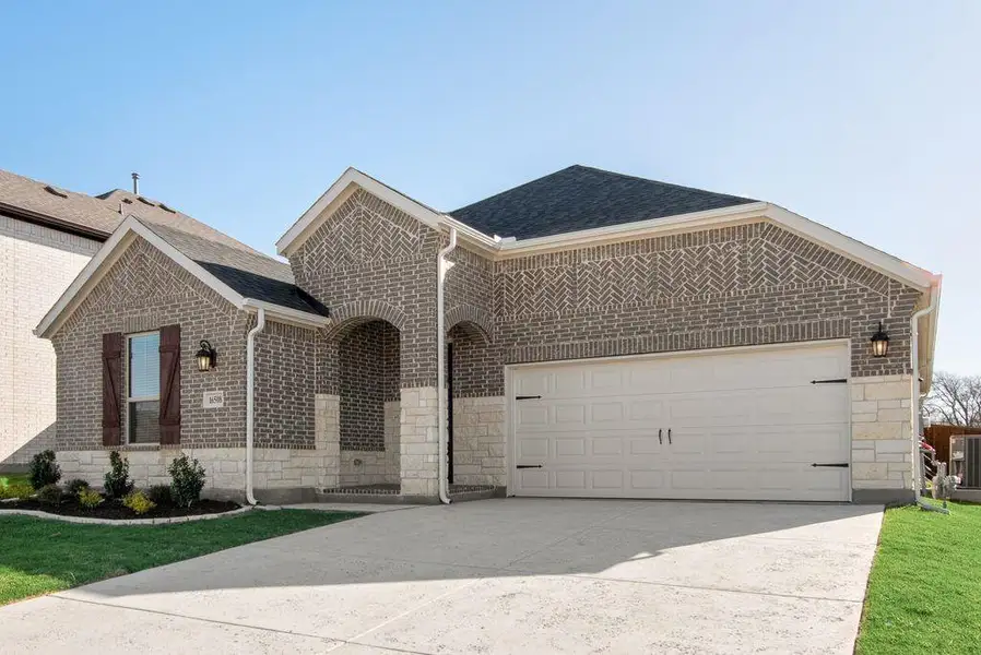 Front exterior of a new home in Wildflower Ranch, Justin, TX, highlighting curb appeal (Image 20). Front exterior of a new home in Wildflower Ranch, Justin, TX, highlighting curb appeal (Image 20).