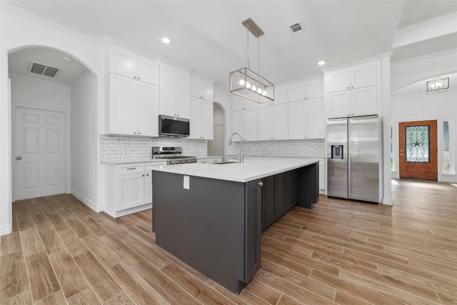 Dark gray center island is a beautiful contrast against the light and bright kitchen with space for family and friends to cook together. Dark gray center island is a beautiful contrast against the light and bright kitchen with space for family and friends to cook together.