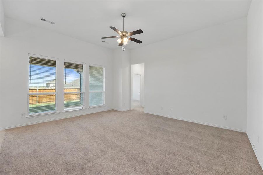 Carpeted spare room with ceiling fan