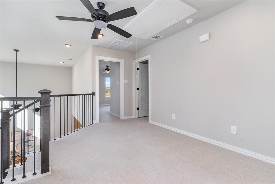 Carpeted spare room featuring ceiling fan