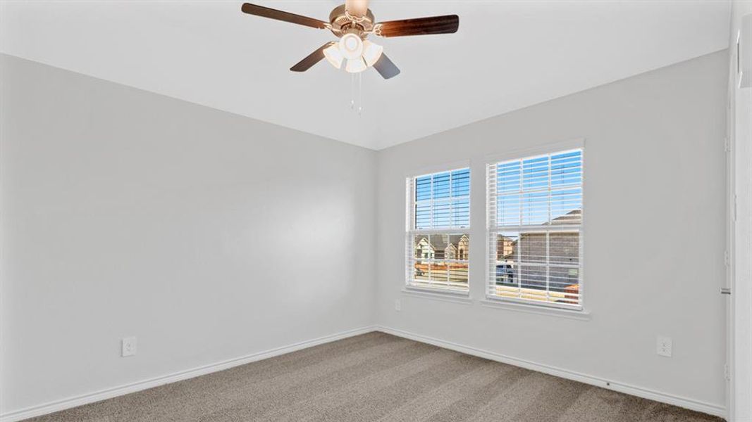Room featuring two windows with blinds, a ceiling fan with integrated lighting, light-toned walls, and carpet flooring