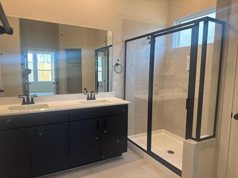 Full bath with a stall shower, healthy amount of natural light, and double vanity Full bath with a stall shower, healthy amount of natural light, and double vanity