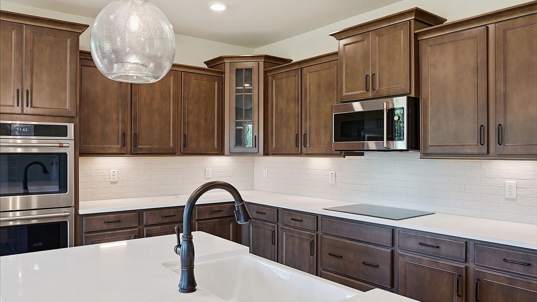 Highly skilled craftsmanship shines in this modern kitchen with pendant lighting and a central island focal point in SC