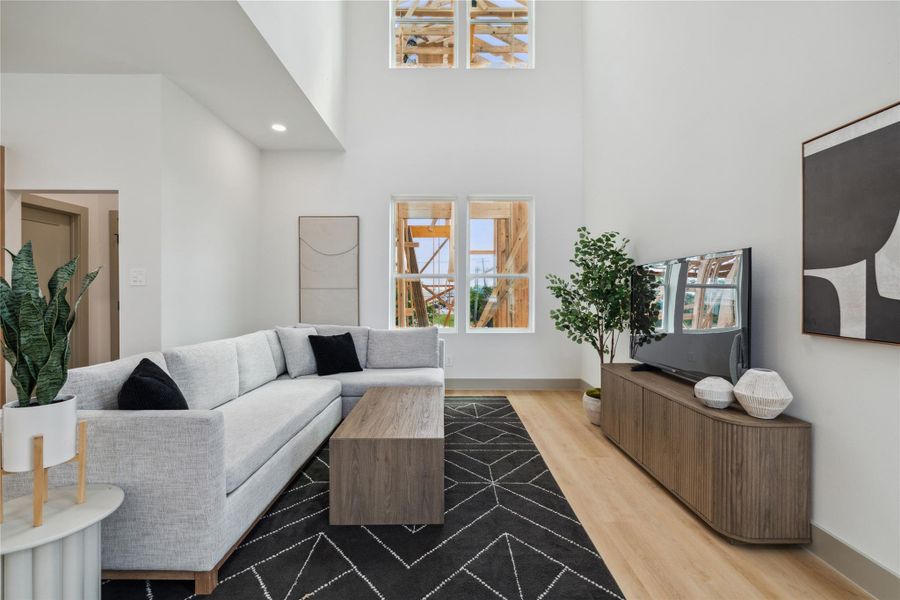Thoughtfully scaled furnishings and wood tones soften the vertical drama of this modern living room retreat.