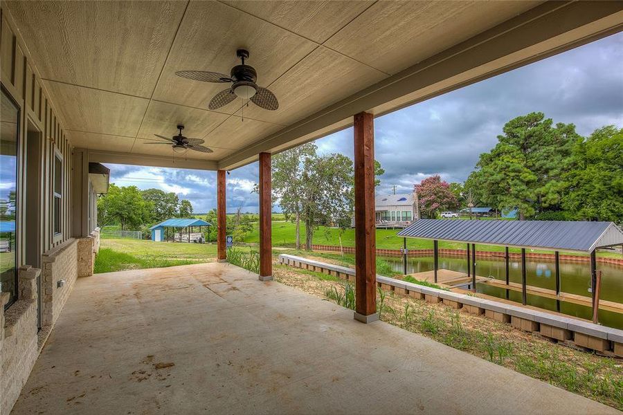 View of patio with a water view and ceiling fan