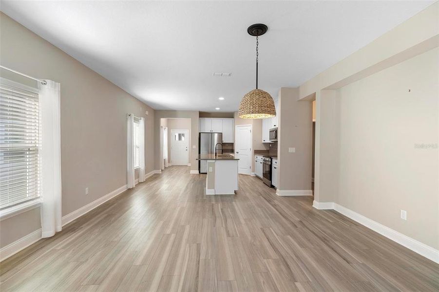 The great room features a perfectly sized dining area with a stylish hanging light fixture that seamlessly ties together the home's beautiful color palette and upgrades.