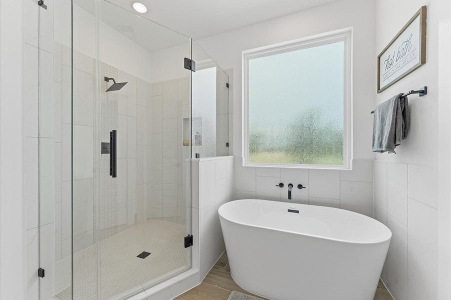 Indulge in everyday luxury in this elegant primary bathroom, where a freestanding soaking tub and a spacious walk-in shower offer the best of both worlds. The frameless glass shower enclosure beautiful tilework, while the tub invites relaxation. A double vanity with quartz countertops and individual mirrors adds modern sophistication, and soft neutral tones create a serene, spa-like ambiance that elevates your daily routine. Indulge in everyday luxury in this elegant primary bathroom, where a freestanding soaking tub and a spacious walk-in shower offer the best of both worlds. The frameless glass shower enclosure beautiful tilework, while the tub invites relaxation. A double vanity with quartz countertops and individual mirrors adds modern sophistication, and soft neutral tones create a serene, spa-like ambiance that elevates your daily routine.