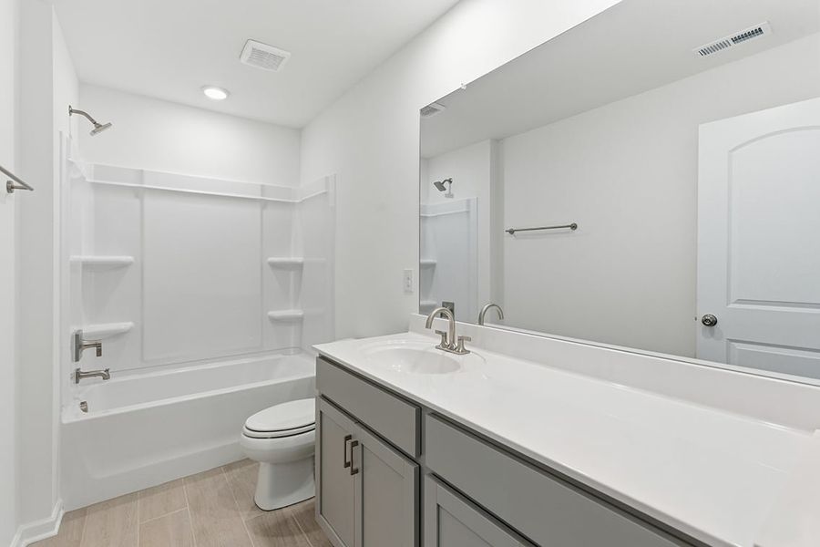 A bathroom with a tub toilet and sink.