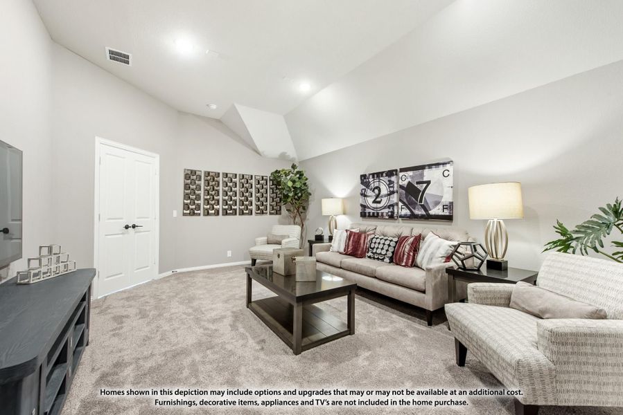Living room with vaulted ceiling, neutral carpet, and gray sofa with red accent pillows