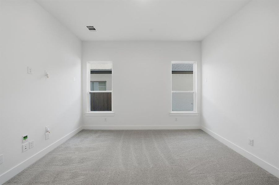 Empty room with light colored carpet and plenty of natural light Empty room with light colored carpet and plenty of natural light
