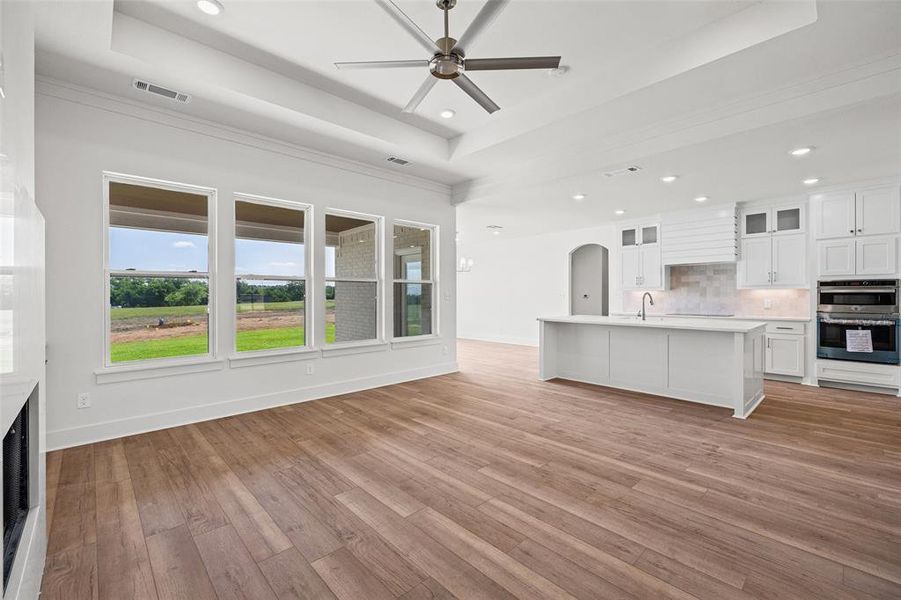 Open-concept living space featuring wood-finish flooring, a contemporary ceiling fan, and recessed lighting