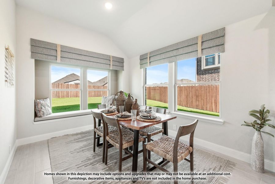 Bright dining area with wood table, woven chairs, window seat, and large windows overlooking backyard
