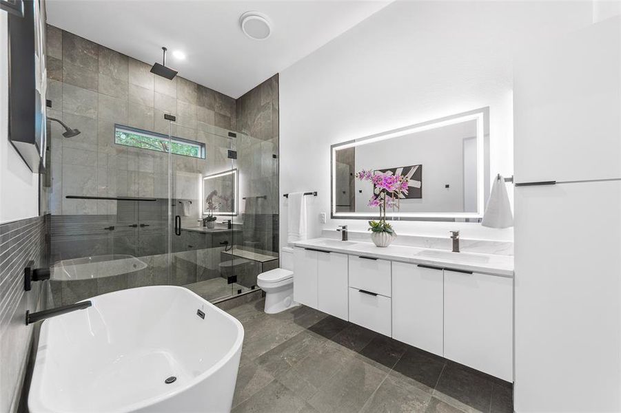 Bathroom with a shower stall, double vanity, and a soaking tub Bathroom with a shower stall, double vanity, and a soaking tub