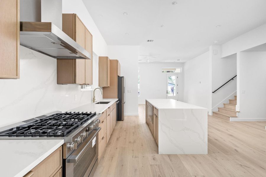 Kitchen with stainless steel appliances, a center island, and light brown cabinets Kitchen with stainless steel appliances, a center island, and light brown cabinets
